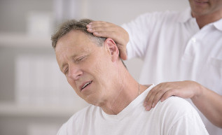 Vīrietis ar kakla osteohondrozi manuālā masiera reģistratūrā